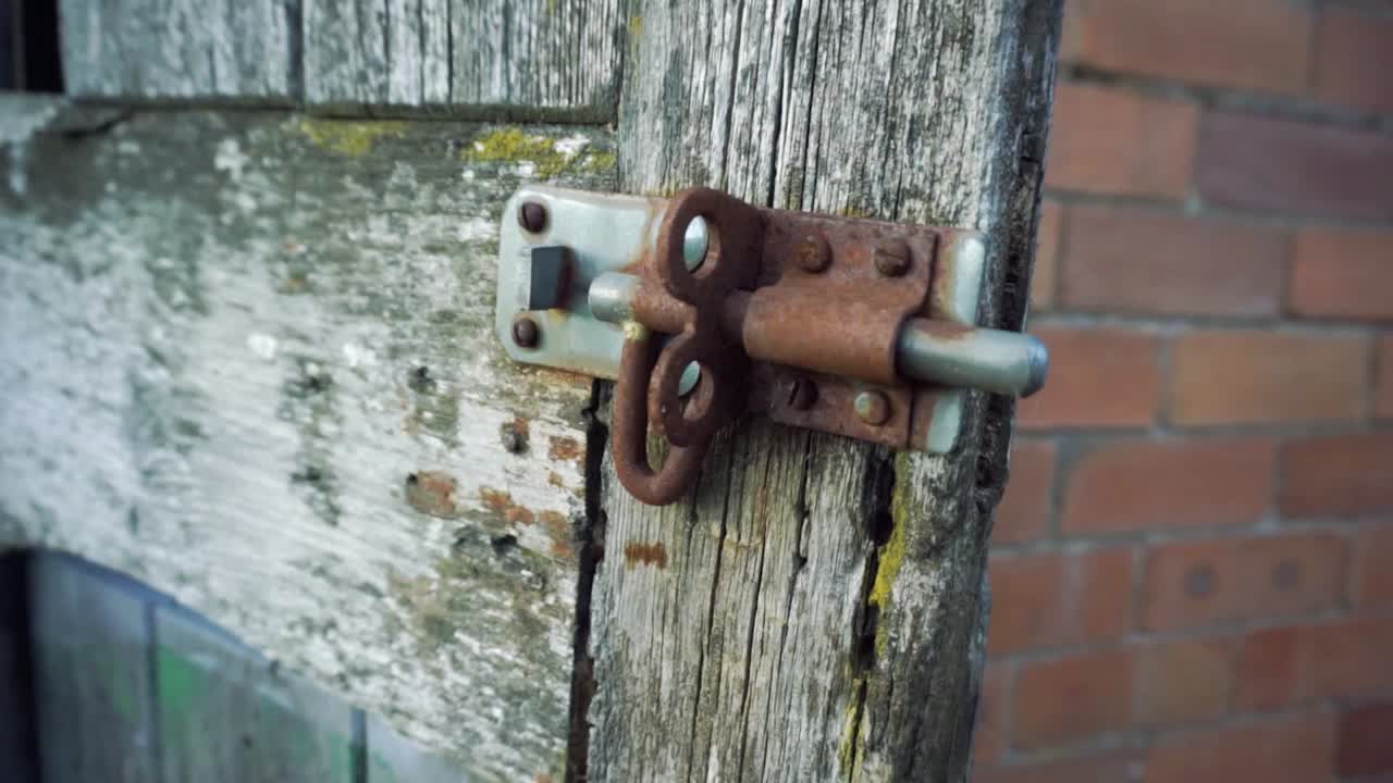 cerradura de perno vieja oxidada en puerta de madera desgastada