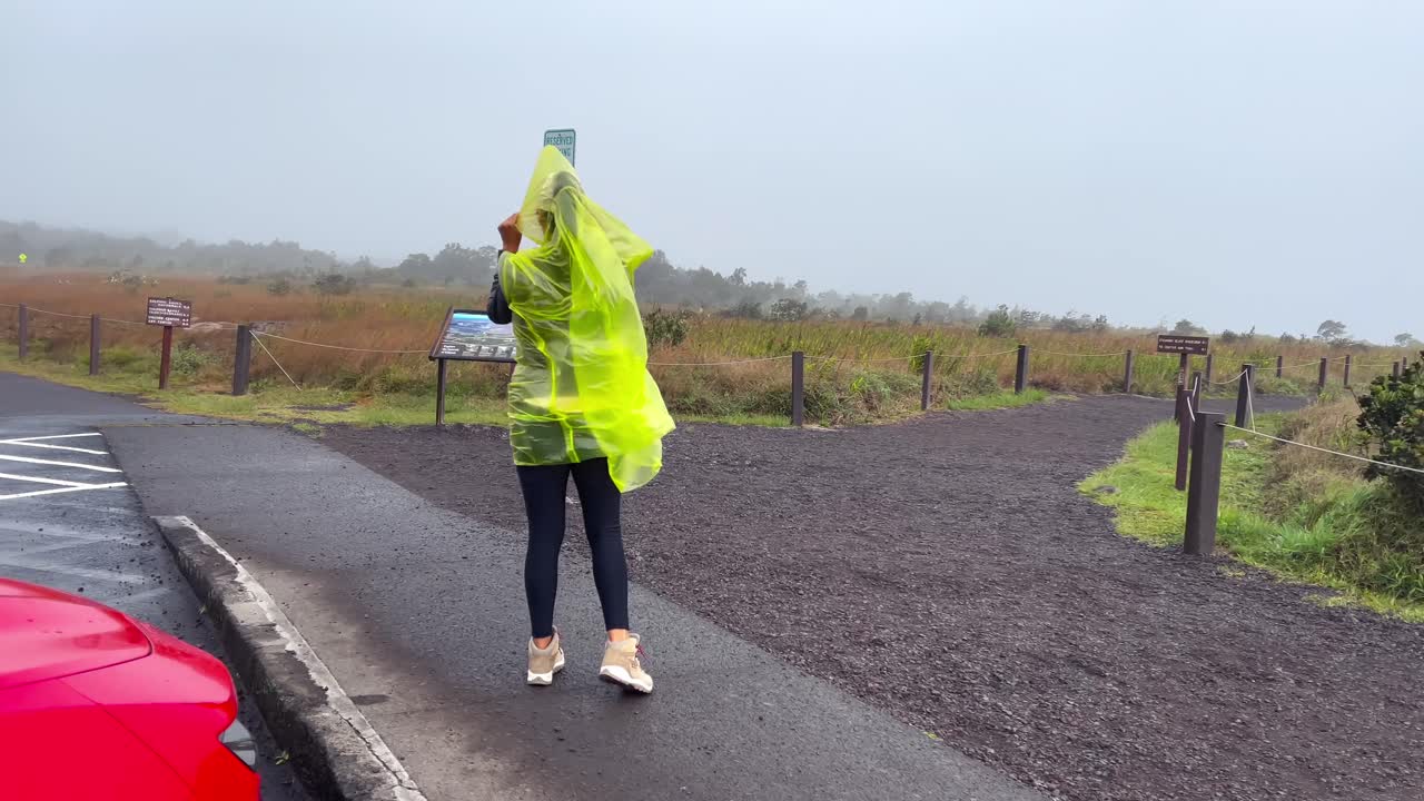 흐린 날 하와이의 마우나 로아 화산 변두리에 비가 내리는 여자