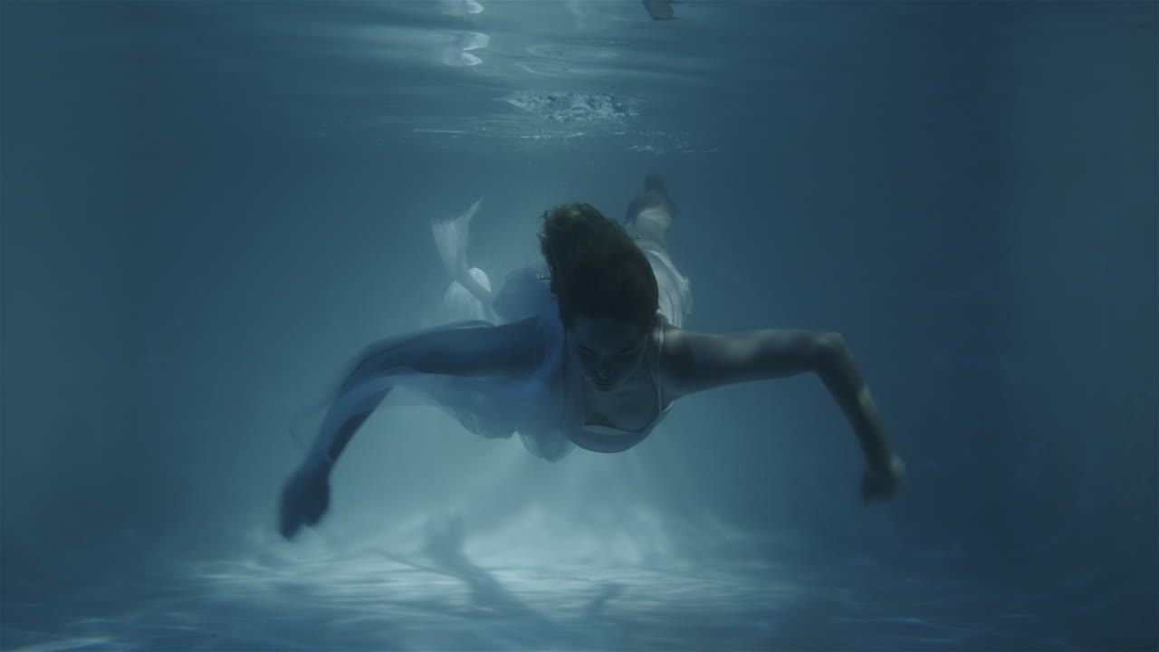 una chica con un vestido blanco flota hacia la cámara en cámara lenta