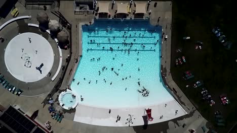 slow ascending aerial shot - people having fun at the turquoise blue water in the wave pool at kandle park in tacoma, washington on a summer day