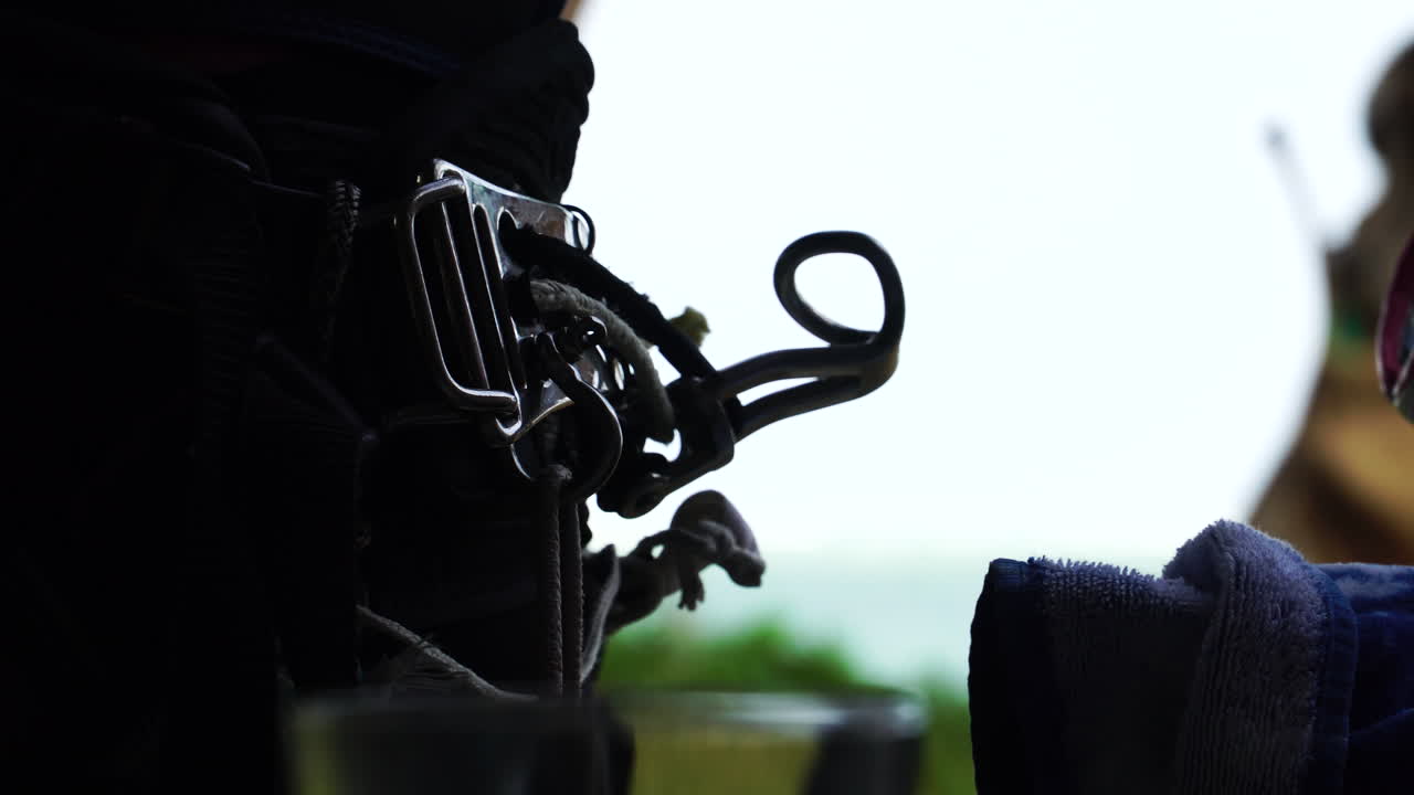 fechar uma foto estática de arnês de windsurf em uma mulher segurando óculos de sol