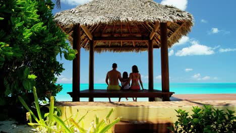 caucasian family outdoors in a tropical beach hut