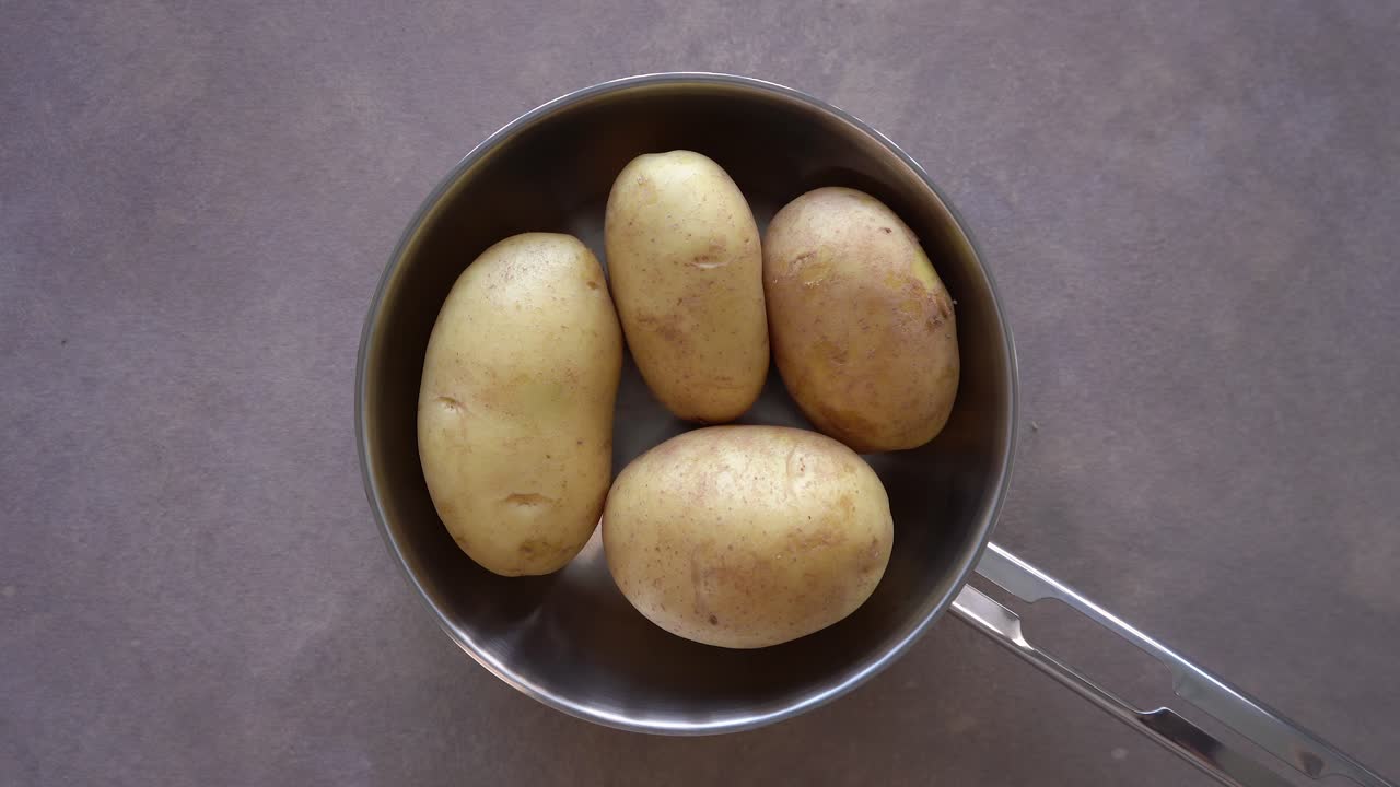 papas crudas en un tazón de acero inoxidable. - gastos generales