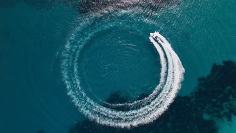 Top-down-drone-shot-of-boat-going-in-circle-turning-with-the-boat