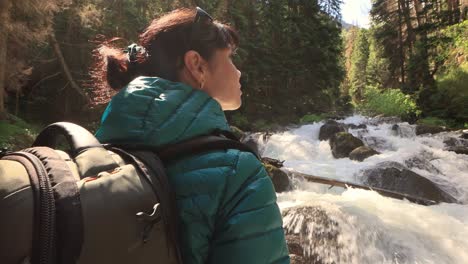 Hiking-woman-walk-with-a-hiking-backpack-in-spring-green-forest