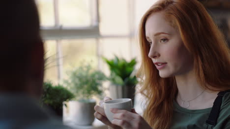 beautiful young woman in cafe talking to friend drinking coffee enjoying relaxed conversation chatting together socializing in restaurant shop