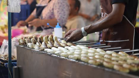 Vendedor-De-Comida-Callejera-De-Tailandia-Asando-Plátanos-Enteros-Horneados