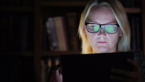 woman in a study with a tablet late at night