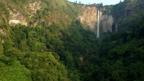 toma de drones de enfoque soleado de acantilados, selva y cascada de sipiso piso en el norte de sumatra, indonesia