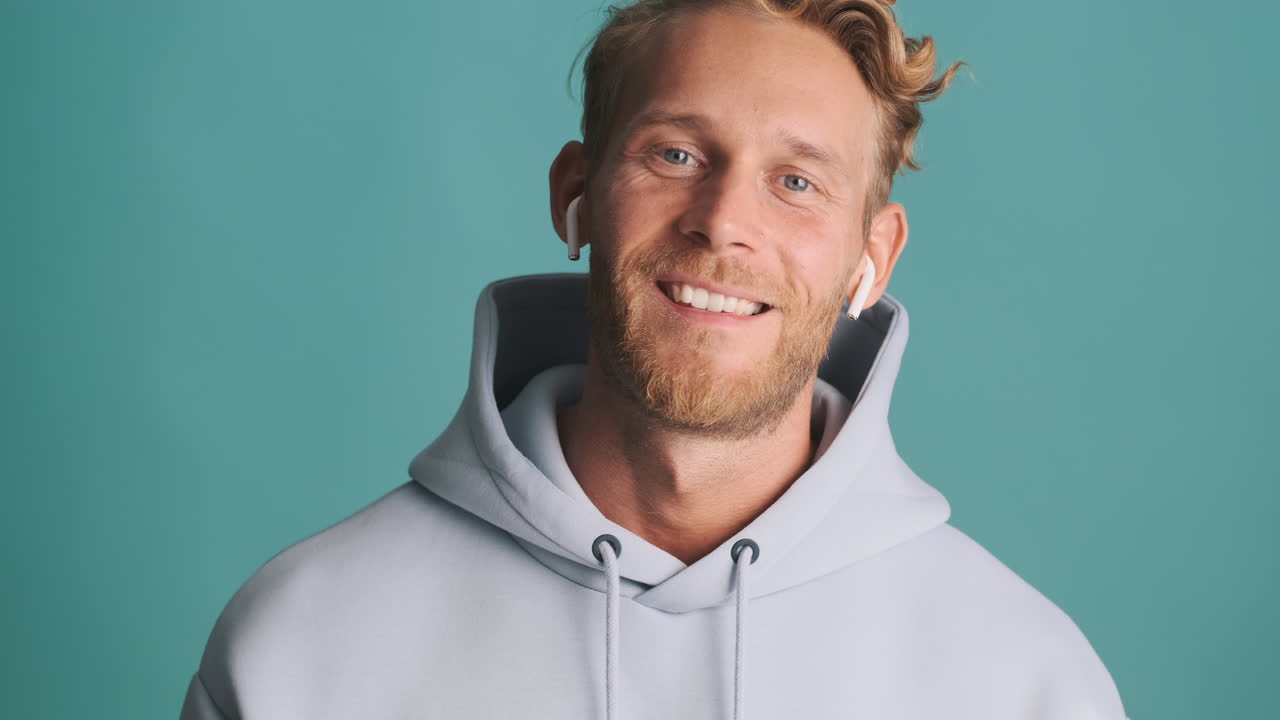 un tipo feliz posando con auriculares.