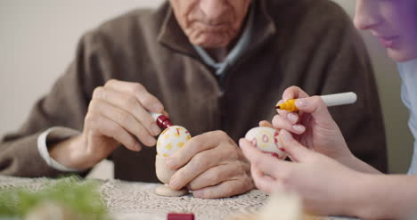 senior man and woman painting easter eggs 6