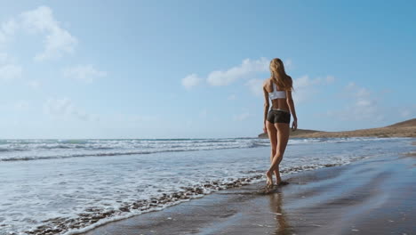 Frau-Läuft-Barfuß-Am-Sommerstrand.-Nahaufnahme-Des-Beins-Einer-Jungen-Frau,-Die-Am-Strand-Entlang-Einer-Welle-Aus-Meerwasser-Und-Sand-Läuft.-Reisekonzept.