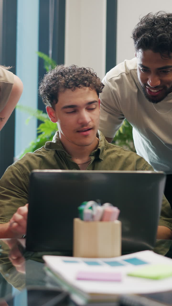 Young Men Collaborating and Working on Laptop in Modern Office