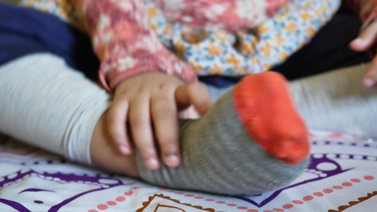 niña sentada y jugando con calcetines
