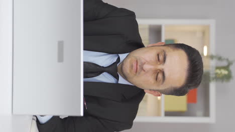 Vertical-video-of-Home-office-worker-man-looking-dull-at-camera.