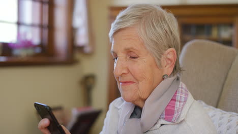 Smartphone,-tea-and-relax-senior-woman-on-sofa