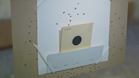 small shooting target suddenly being hit by a bullet