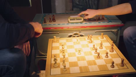 the hands of two chess players move the pieces alternately, taking some chess pieces off the chess board