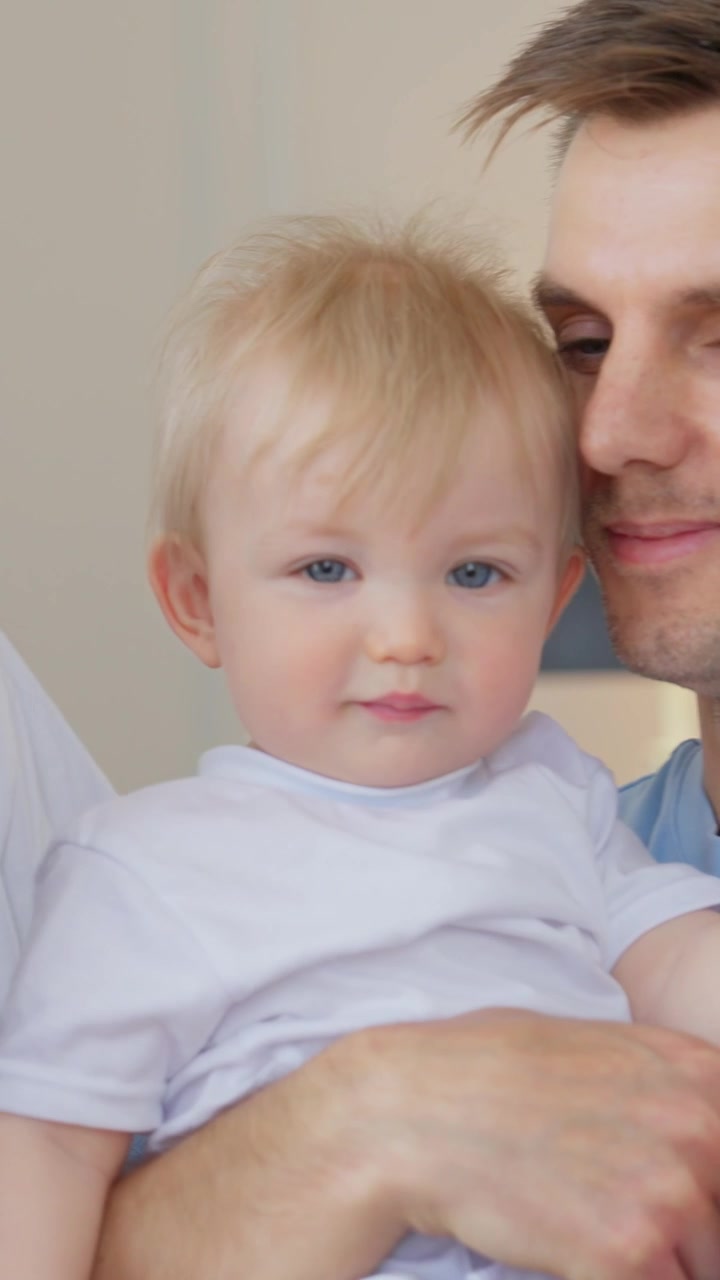 Adorabile bambino biondo tenuto in braccio da genitori amorevoli