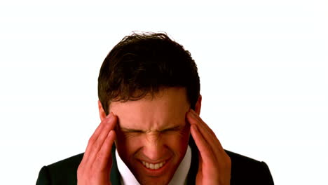 un hombre de negocios con dolor de cabeza frotándose la cabeza.