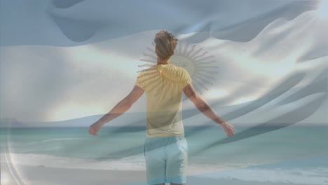standing on beach, man holding argentina flag with sun emblem animation