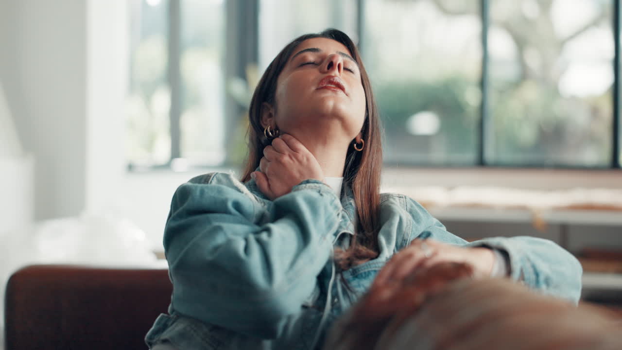 Mujer con dolor de cuello sentada en el sofá