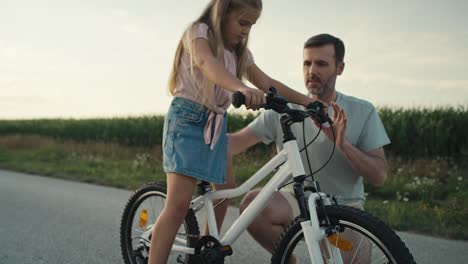 caucasian father teaching his little daughter how to ride a bike.