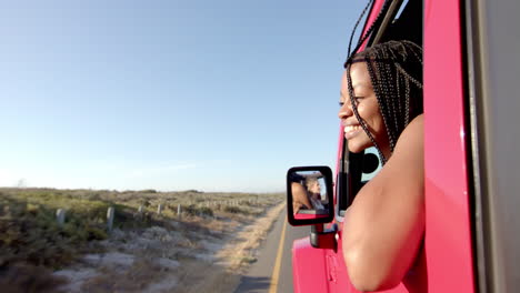 joven mujer afroamericana disfruta de un paseo en coche en un viaje por carretera, con espacio de copia