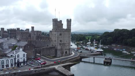 ancient caernarfon castle welsh harbour town aerial view medieval waterfront landmark fast dolly left low angle