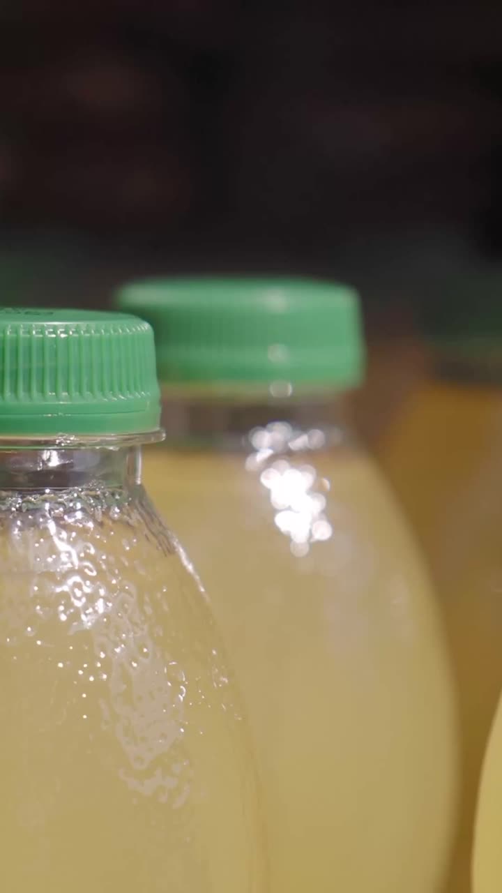 Primer plano de una refrescante botella de jugo amarillo con tapa verde.