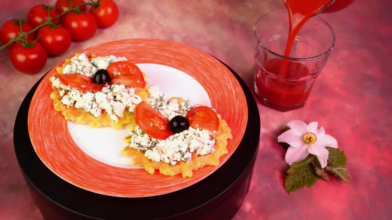 sándwich vegetariano con queso cottage, eneldo, tomates y aceitunas, girar lentamente. verter jugo de tomate en el vaso de beber. luz rosa.