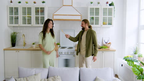 una pareja cantando en la cocina.