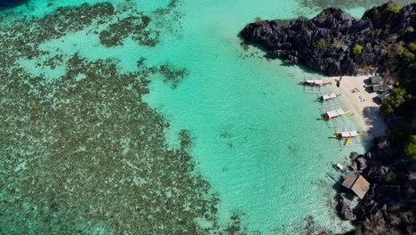 Top-down-drone-footage-of-a-beach-with-boats-on-Coron-island-in-the-Philippines