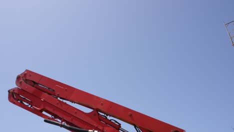 View-of-the-hydraulic-arm-of-a-concrete-pump-rising-against-the-sky