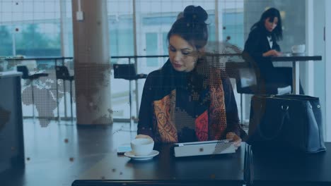 animation of world map and dots over caucasian woman drinking coffee and using smartphone