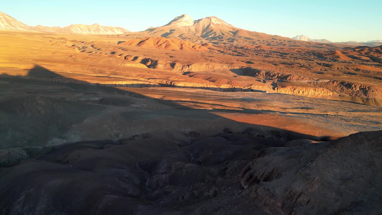 Drone footage flying over Chile’s Valle de la Luna, with rugged desert terrain glowing in soft twilight colors