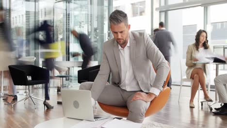 time-lapse of businessman talking on mobile phone while using laptop