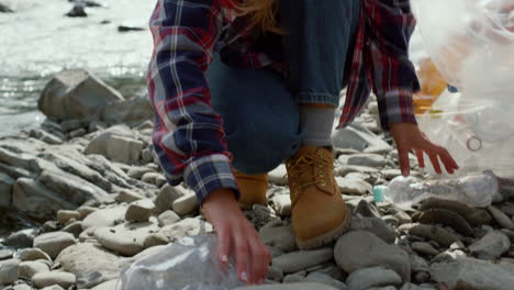 woman and man picking trash at river. tourists collecting waste for recycle