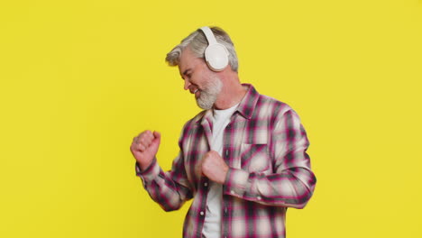 happy caucasian man listening music on headphones and dancing disco fooling around having fun
