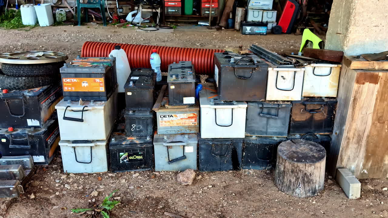 Stacked Used Car Batteries and Workshop Supplies in a Garage