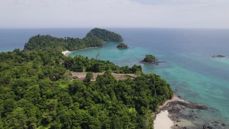 Aerial-view-showcasing-a-tropical-Coiba-Island-in-Panama-with-dense-greenery-surrounded-by-crystal-clear-blue-waters