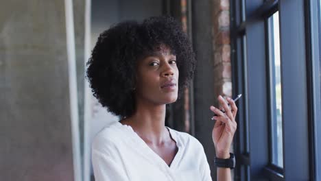 Happy-african-american-woman-standing-in-cafe-looking-at-camera-and-smiling