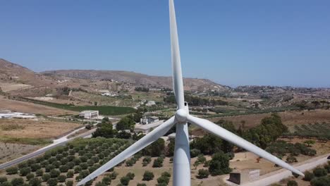 Turbina-De-Viento-Girando-En-El-Viento-En-La-Cima-De-Una-Colina-Mediterránea,-Alejamiento-Del-Cierre-Aéreo