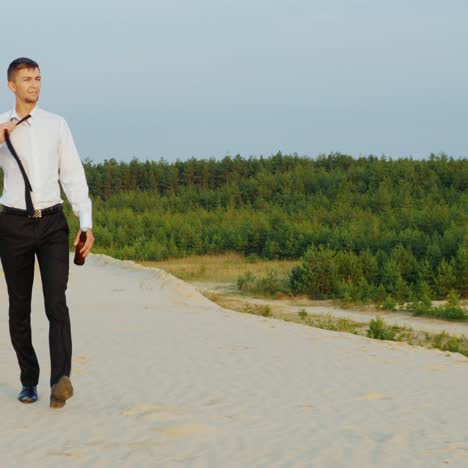 a businessman with a bottle of alcohol walks forward on the sand 1