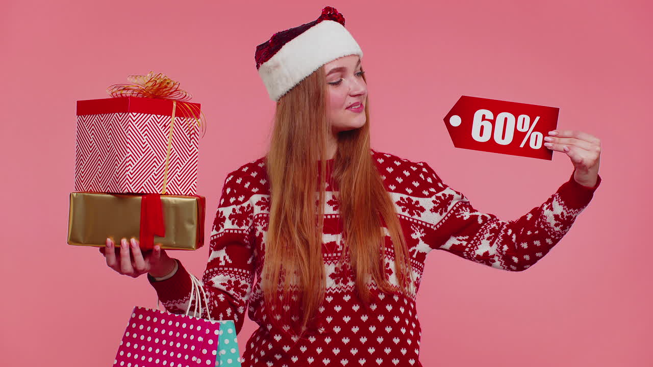mujer con suéter de navidad mostrando cajas de regalos y inscripciones de descuento del 60 por ciento nota de texto de banner