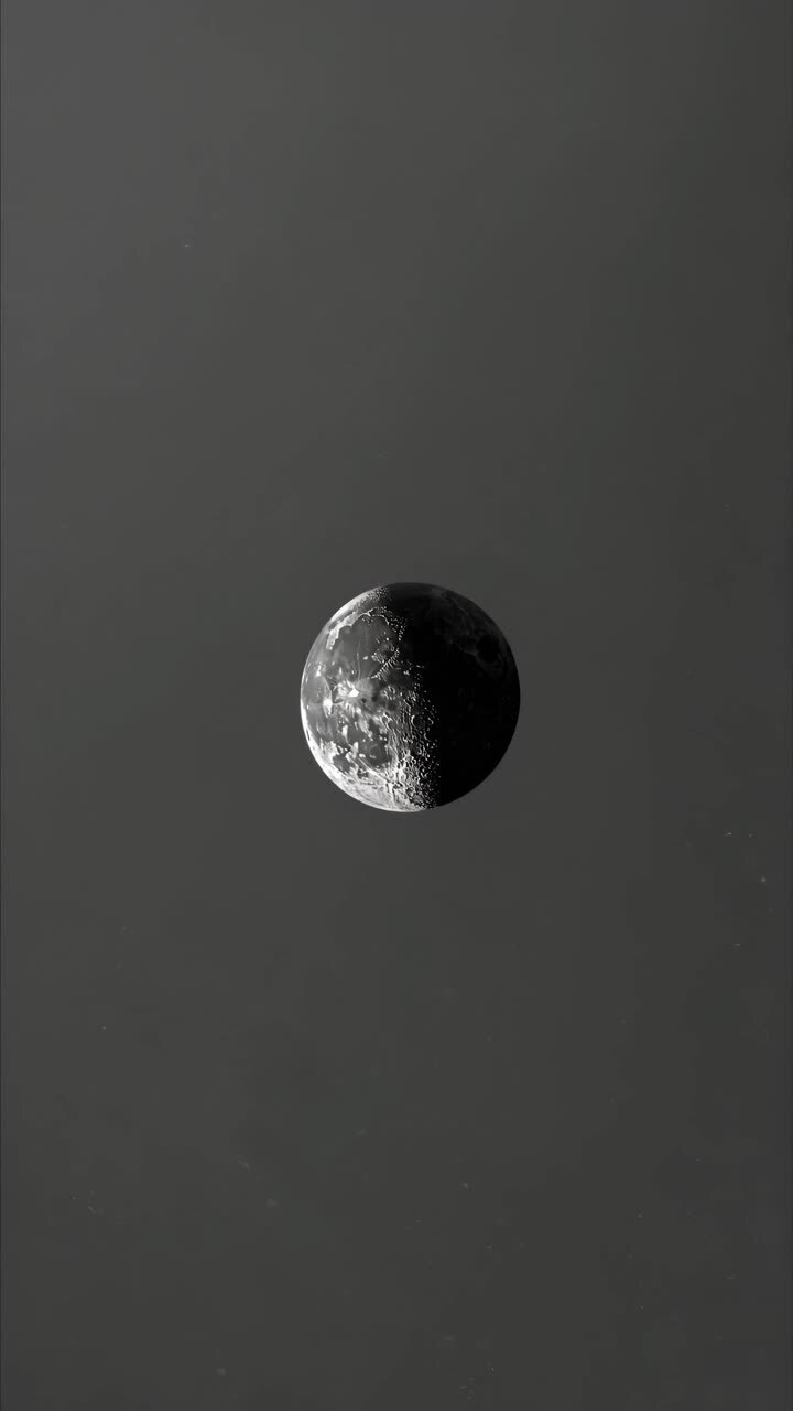 Conceito de vídeo minimalista de uma lua meio iluminada no espaço, capturada de um ângulo distante