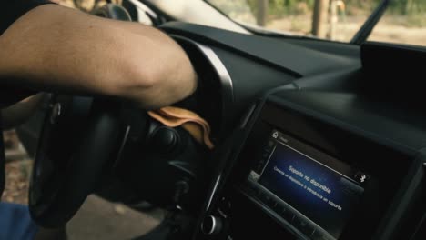 cerca de un hombre con guantes negros limpiando un auto blanco con interior negro con un paño de microfibra en cámara lenta