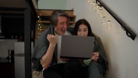 Young-man-woman-in-love-cuddle-together-on-the-stairs-feel-excited-after-getting-victory