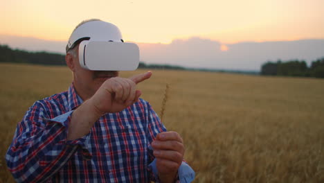 Un-Granjero-Adulto-Mayor-Utiliza-La-Realidad-Virtual-Para-La-Agricultura-Sosteniendo-Una-Espiguilla-En-Sus-Manos-Y-Presionando-Su-Dedo-Sobre-El-Grano-Usando-Tecnología-Y-Gráficos-Modernos.