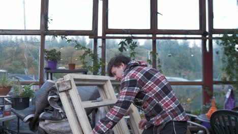 young caucasian man swinging hatchet to chop logs